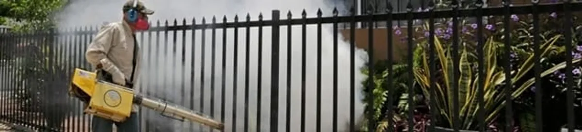 Mosquito control technician fogging a yard perimeter for mosquito reduction in Riverside, CA